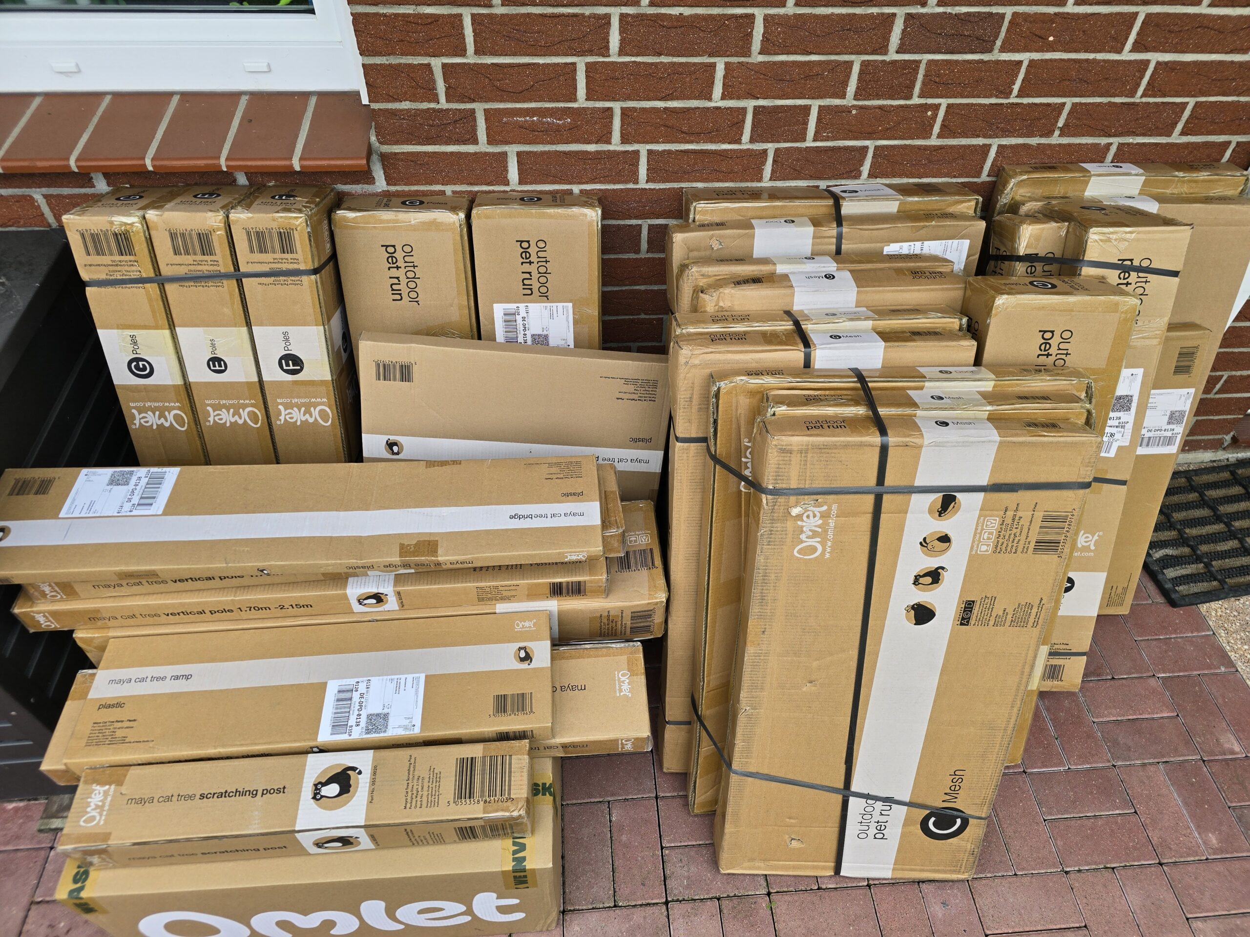 34 Pakete für den Katzengehege-Aufbau stehen im Garten bereit