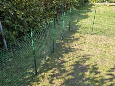 Grünes Katzengehege mit Dachbogen im Garten, teilweise fertig montiert