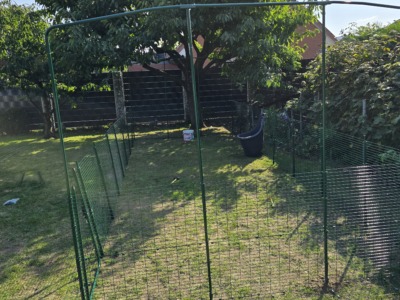 Rahmen mit Dachbogen für ein Katzenaußengehege im Garten unter einem Baum
